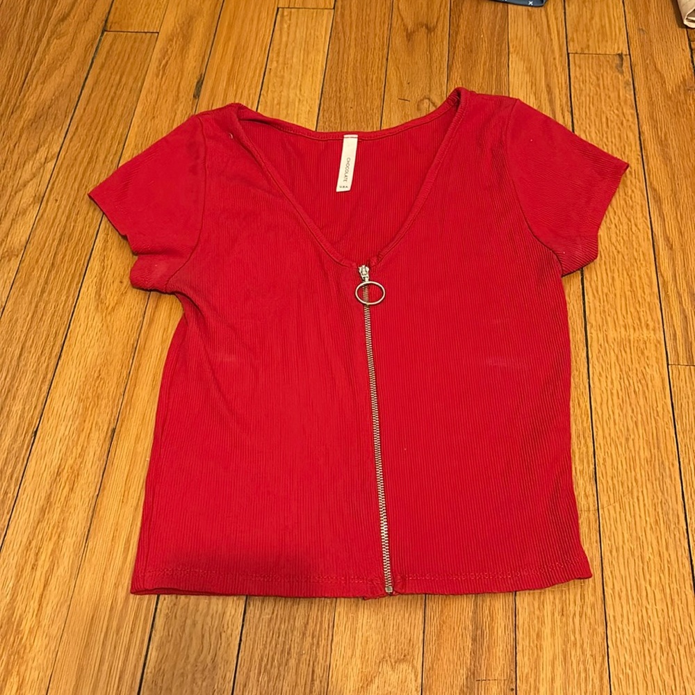 Red short sleeve top with zipper down the middle.